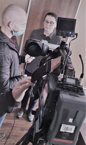 Pokaż zdjęcie: na pierwszym planie kamera, a w tle reporter z mikrofonem z logo TVP3 oraz udzielająca wywiadu Anna Wankiewicz-Lewandowska - specjalitsa ds. CIDON-u w Kujawsko-Pomorskim Oddziale PFRON