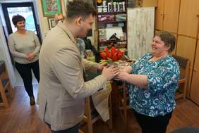 Pokaż zdjęcie: Jedna z uczestniczek wręcza Panu Dyrektorowi wykonany z materiału bukiet tulipanów w pączkach