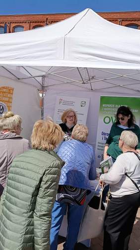 Pokaż zdjęcie: Przy stoisku Łódzkiego Oddziału PFRON stoją przedstawiciele, którzy udzielają odpowiedzi na temat dostępnych form wsparcia dla osób z niepełnosprawnościami. 