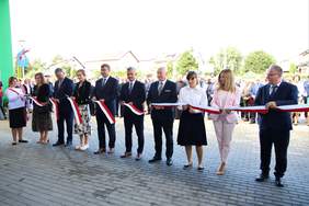 Pokaż zdjęcie: Przedstawiciele władz, zaproszonych instytucji oraz szkoły przecięli biało-czerwoną wstęgę, na znak symbolicznego otwarcia budynku. 