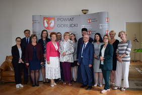 Pokaż zdjęcie: Kobiety oraz mężczyźni uczestniczący w zawarciu umowy pozują z dokumentami