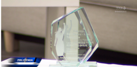 Szklana statuetka, na któej wygrawerowano postać kobiety z uniesioną ręką oraz dane laureatki i informacje dot. konkursu
