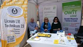 Na Rynku łódzkiej Manufaktury znajduje się stoisko Centrum Informacyjno-Doradczego dla Osób z Niepełnosprawnościami Łódzkiego Oddziału PFRON oraz Ośrodka Wsparcia i Testów w Łodzi. Przy stoisku siedzą trzy osoby: dwie kobiety i mężczyzna. 