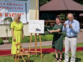 trzy osoby dwie kobiety i mężczyzna uczestniczą w jakiejś zabawie