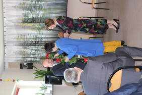 Pokaż zdjęcie: Kobieta ubrana na niebiesko wręcza trzy róże mężczyźnie w garniturze