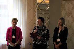 Pokaż zdjęcie: Trzy kobiety, jedna na środku z mikrofonem