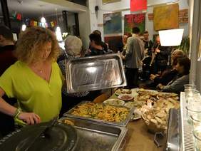 Pokaż zdjęcie: Stół z potrawami, przy nim kobieta.