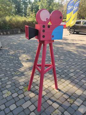 Pokaż zdjęcie: Papierowa, różowa kamera filmowa jako rzeźba