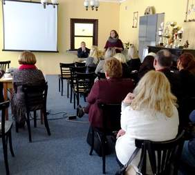 Uczestnicy spotkania, Kierownik WTZ "Arkadia"  Jacek Orzeł (siedzi przodem) oraz przemawia Prezes Fundacji "Arkadia" - Marta Hewelt