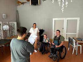 Pokaż zdjęcie: Ćwiczenie sceny z przedstawienie. Pokazane osoby na wózku w trakcie próby