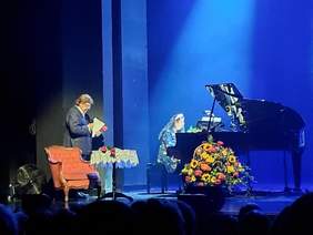 Pokaż zdjęcie: Na scenie stoi Marcel Pacholczyk ze Stowarzyszenia Studio Integracji. Trzyma w dłoniach mikrofon i śpiewa piosenkę. 