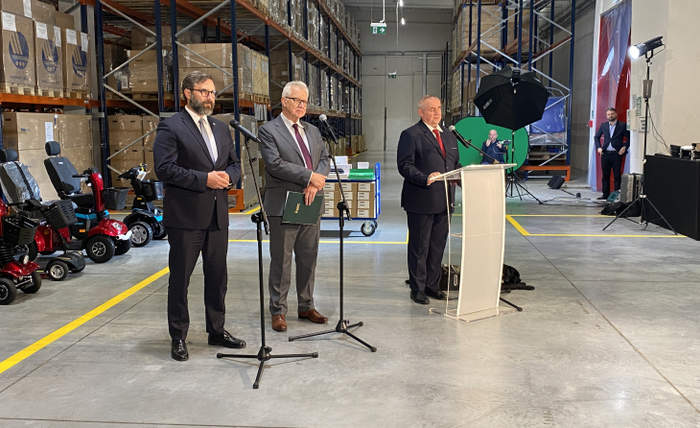 Pokaż zdjęcie: Na zdjęciu stoi trzech mężczyzn przemawiających do publiczności
