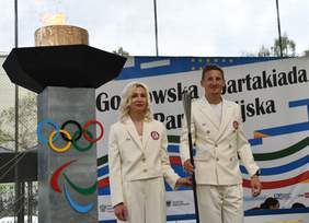 Pokaż zdjęcie: Na biało ubrana dwójka zawodników "Start" Zielona Góra idzie zapalicz znicz Spartakiady