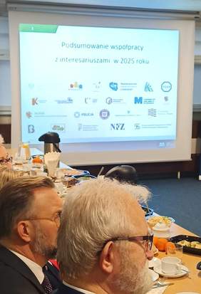 Napis na białym ekranie, zamieszczono logotypy różnych instytucji