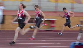 Pokaż zdjęcie: trzej mężczyźni ubrani w stroje sportowe biegną po bieżni.