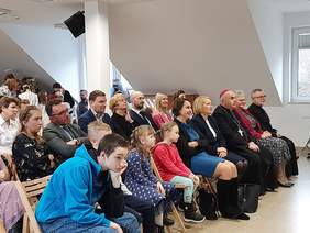 Pokaż zdjęcie: Zdjęcie widowni, osób siedzących na krzesełkach. Wśród zebranych gości ks. biskup Adam Bab