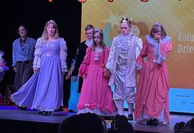 Pokaż zdjęcie: Widzimy ubranych w stoję barokowe aktorów odgrywających przedstawienie 