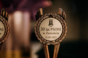 Pokaż zdjęcie: Zdjęcie statuetki, okrągłej w kolorze złotym, statuetka na 30-lecie PSONI Zamość