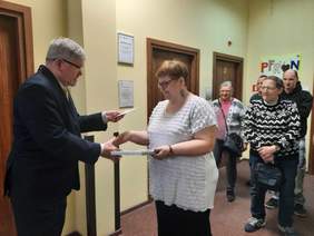 Pokaż zdjęcie: Dyrektor Łódzkiego Oddziału PFRON składa gratulacje zwyciężczyni konkursu. Ponadto wręcza laureatce pamiątkowy dyplom i kartę podarunkową. 