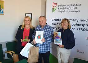 Pokaż zdjęcie: Mężczyzna - Laureat oraz dwie kobiety. Laureat trzyma nagrody