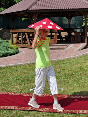 kobieta z kapeluszem muchomor na czerwonym dywanie