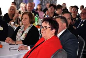 Przy stole, pokrytyym białym obrusem, siedzą zaproszeni goście, po lewej stronie Dyrektor Kujawsko-Pomorskiego Oddziału PFRON - Aleksandra Gierej, w tle widać kolejnych uczestników balu