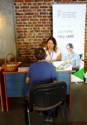 Pracownik K-PO PFRON - Ewa Niedlich - udziela porad w punkcie informacyjnym 