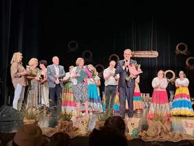 Na scenei stoją gospodarze Festiwalu, osoby prowadzące oraz zaproszeni goście, którzy - z kwiatami w rękach - skłądają gratulacje.