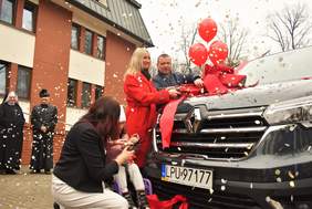 Pokaż zdjęcie: Zdjęcie kobiety blondynki przecinającej wstęgę na samochodzie bus marki renault