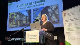 Pokaż zdjęcie: Kobieta przy mównicy z logo PFRON w trakcie wystąpienia, a za nią wyświetlona prezentacja i baner CIDON