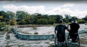 Dwóch mężczyzn na wózkach inwalidzkich - ujęcie z wideoklipu zespołu Skołowani