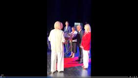 Na scenie stoją organizatorzy i goście, którzy odbierają podziękowania