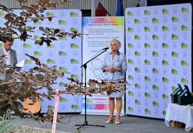 Prezes Fundacji podczas przemówienia na oficjalnym otwarciu, w tle dwa banery Hospicjum "Nadzieja" oraz Fundacji Społeczno-Charytatywnej "Pomoc Rodzinie i Ziemi w Toruniu"