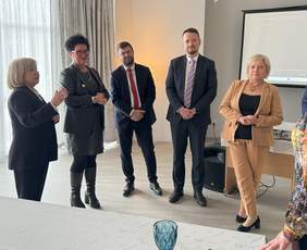 Pokaż zdjęcie: Cztery osoby pozują do zdjęcia, trzy kobiety, od lewej, dwóch mężczyzn w środku i kobieta po prawej. 