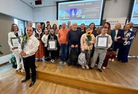 Grupa Laureatów pozuje do zdjęcia na scenie. Trzymają kwiaty, dyplomy i statuetki.