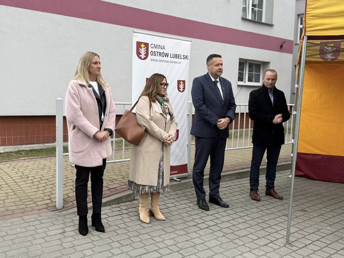 Pokaż zdjęcie: Dwie kobiety i dwóch mężczyzn stoi na dworze w związku z przekazaniem auta.