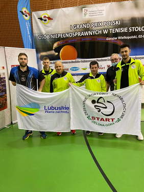Pokaż zdjęcie: Zawodnicy Start Zielona Góra z flagą klubu i Urzędu Marszałkowskiego na tle baneru Grand Prix