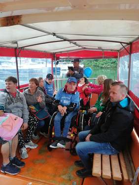 grupa osób siedzi na ławeczka na jachcie