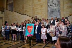 Pokaż zdjęcie: na schodach muzeum narodowego stoi grupa laureatów konkursu plastycznego, trzyma w ręku dyplomy