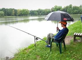Pokaż zdjęcie: Uczestnik Zawodów Wędkarskich łowiący w deszczu