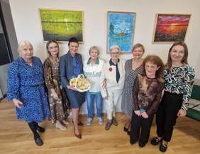 Pokaż zdjęcie: Grupa kobiet stojąca na tle obrazów