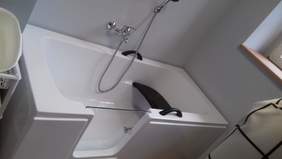 Pokaż zdjęcie: Wanna przystosowana do potrzeb osoby niepełnosprawnej ze szklanymi drzwiczkami, uchwytami i miejscem do siedzenia 