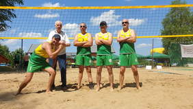 Pokaż zdjęcie: Siatkarze na tle boiska do gry przy siatce