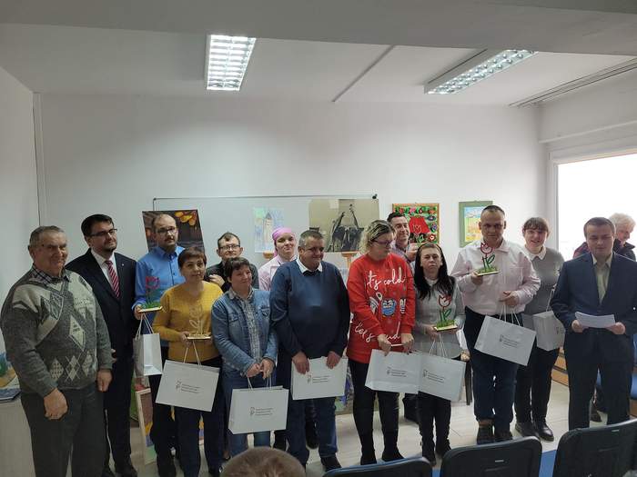 Pokaż zdjęcie: W sali konferencyjnej Oddziału PFRON w Zielonej Górze stoją obok siebie zwycięzcy w etapie wojewódzkim konkursu "Sztuka Osób Niepełnosprawnych" wraz z Dyrektorem Oddziału i pracowniiem Oddziału. Wszyscy są uśmiechnięci, zadowoleni, stoją na t