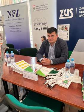 Pokaż zdjęcie: Przedstawiciel PFRON dysponował broszurami i informatorami dotyczącymi pomocy osobom z niepełnosprawnością. 