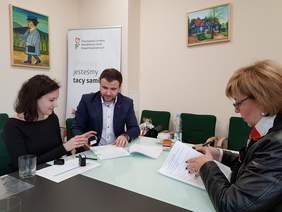 Pokaż zdjęcie: Dyrektor Marta Mordarska podpisuje umowę w ramach programu "Absolwent" z przedstawicielami  Stowarzyszenia na Rzecz Zrównoważonego Rozwoju Społeczno-Gospodarczego „KLUCZ” Adamem Kamionką, Prezesem Zarządu oraz Ewą Kanią, Wiceprezes.