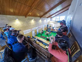 Pokaż zdjęcie: XV Ogólnopolski Turniej Wyciskania Sztangi Leżąc Ostrów Mausz - zdjęcie wykonane z góry, z trybun, zawodnik podnosi sztangę