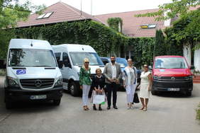 Pokaż zdjęcie: Grupa osób stojąca na tle 4 samochodów