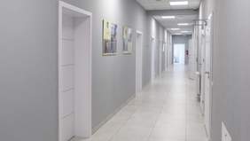 Pokaż zdjęcie: Korytarz pomalowany na szaro z białymi drzwiami