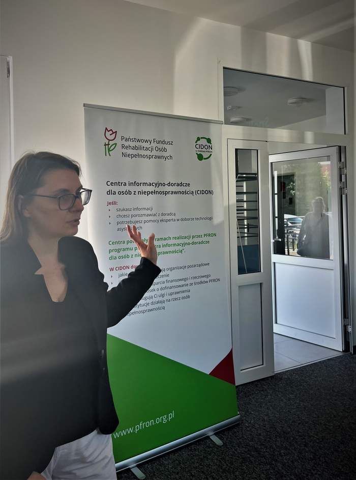 Anna Wankiewicz-Lewandowska - podczas prelekcji - w tle baner PFRON